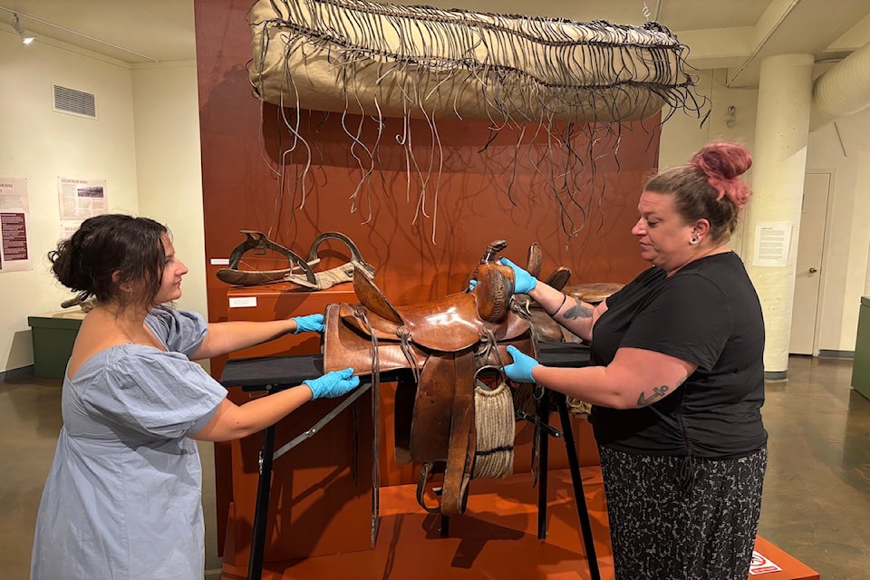 Elizabeth, Collections Associate, and Jas, Head of Exhibitions prepare "Ranching and Rodeos in the Okanagan" exhibit.