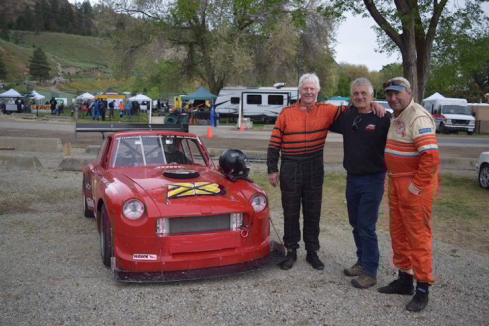 Allen Reid, Brian Browning, and Cory Ussyk (left to right) stand next to their red 1970 MGBGT in the pit at the 66th annual Knox Mountain Hill Climb in Kelowna. 