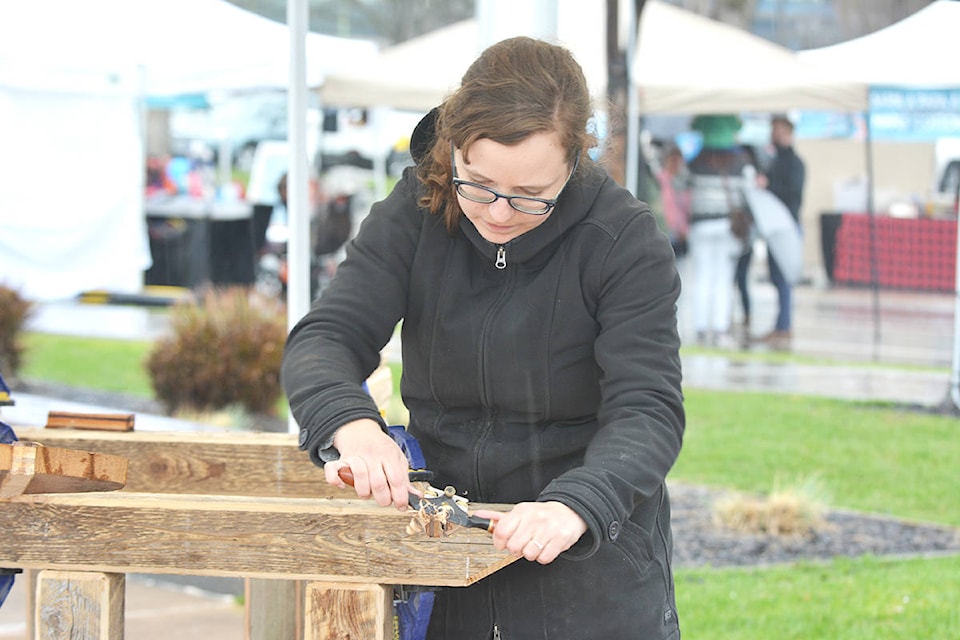Aimee Jensen, with Wooden Arm, performs a carving demonstration to create a paddle Saturday, April 7 during the 40th annual MapleFest in Stuart Park. - Credit: Carli Berry/Capital News