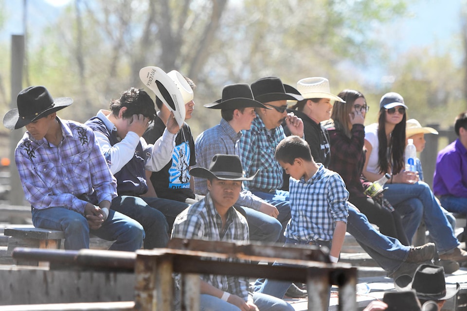 Sitting on the rough grandstands with the spectators, cowboys wait their turn in the ring. (Mark Brett - Western News)