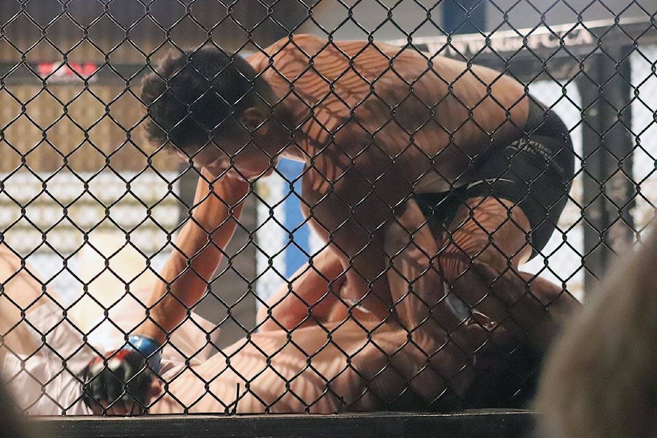 Vernon’s Jordan Cabrejos of Unity Mixed Martial Arts (top) rains blows upon Calgary’s Will Grieves in one of three main event fights at XFC Unbanned Saturday at the Vernon Curling Club. Grieves failed to answer the bell for the fourth round, giving Cabrejos the XFC Middleweight championship. (Roger Knox - Morning Star)