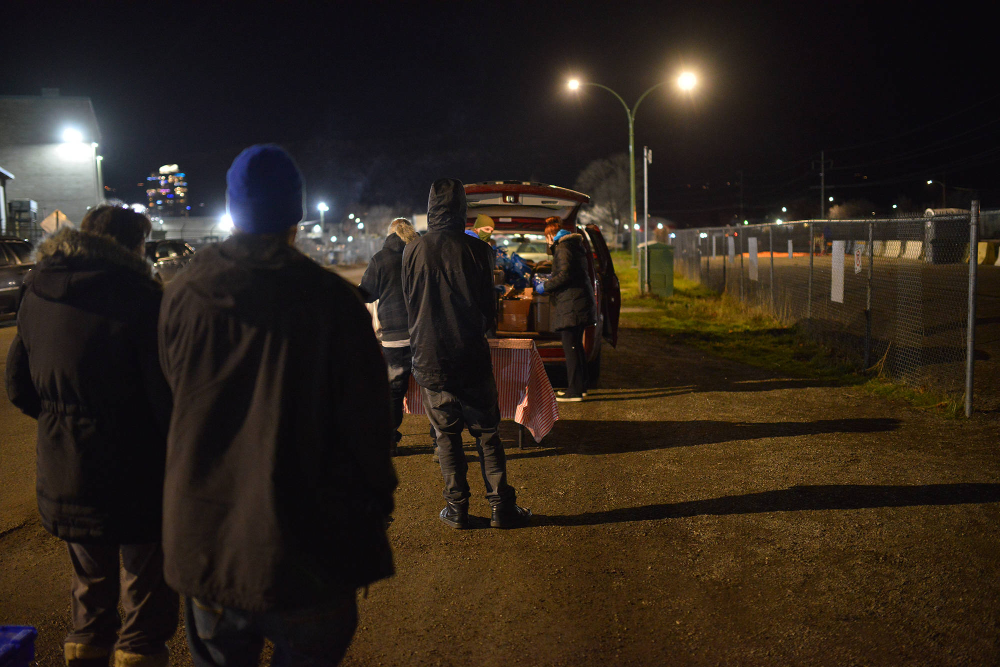 Dozens wait in line for meals being handed out by the Kelowna Gospel Mission, on Baillie Avenue. (Phil McLachlan - Capital News)