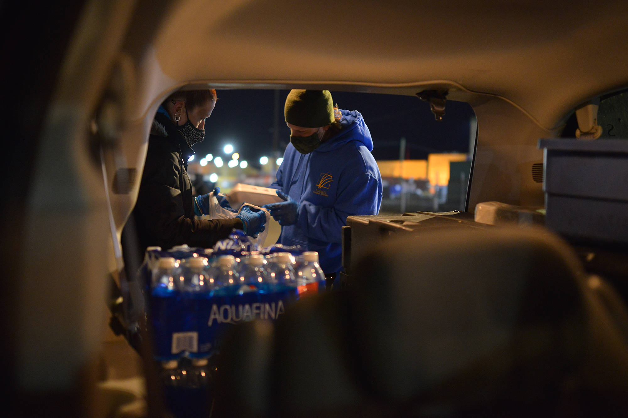 Gospel Mission volunteers hand out meals on Baillie Avenue in Kelowna, Saturday night (Dec. 19). (Phil McLachlan - Capital News)