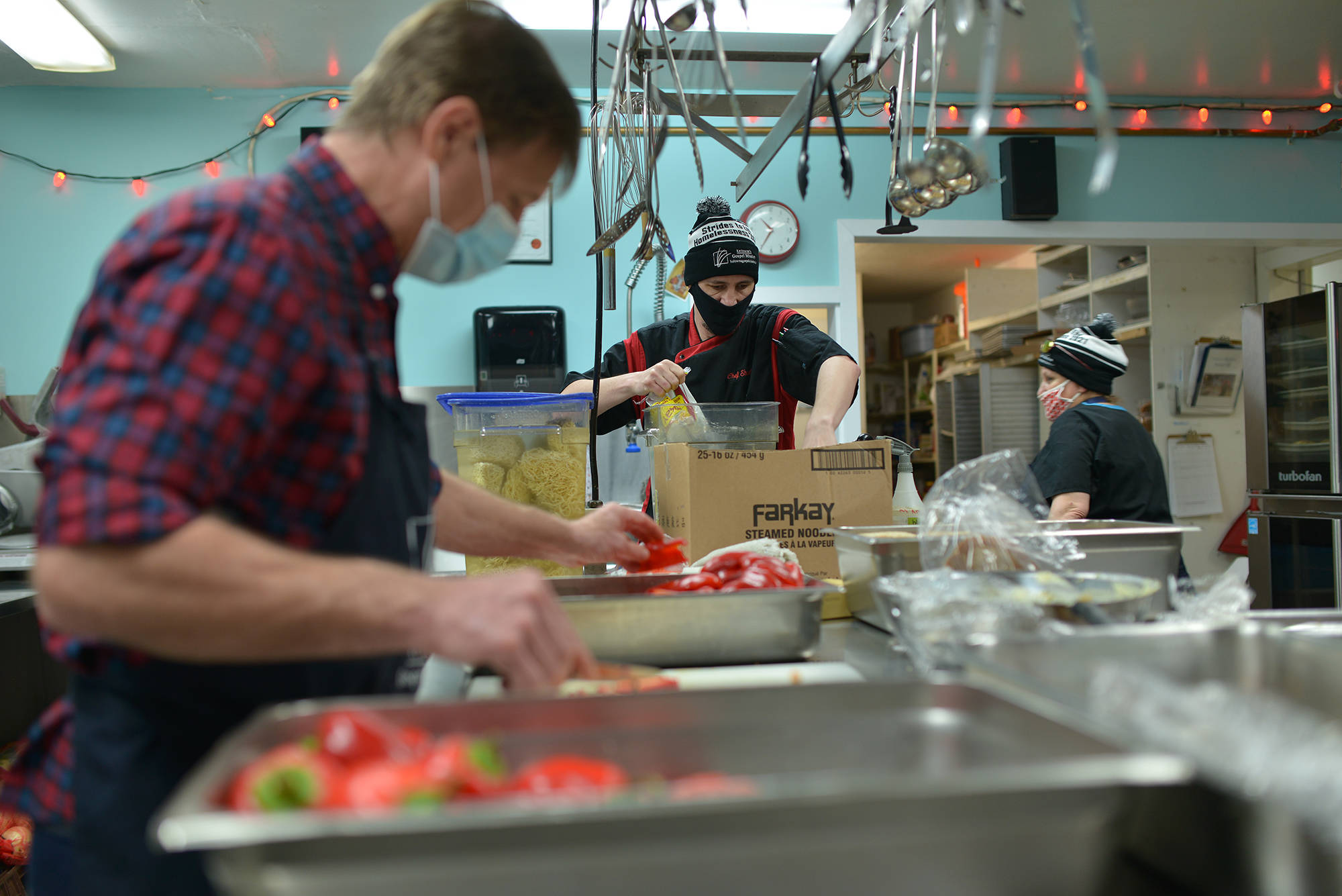 David Short (middle) is pictured on Jan. 26 prepping food in the Gospel Mission shelter kitchen. (Phil McLachlan - Capital News)