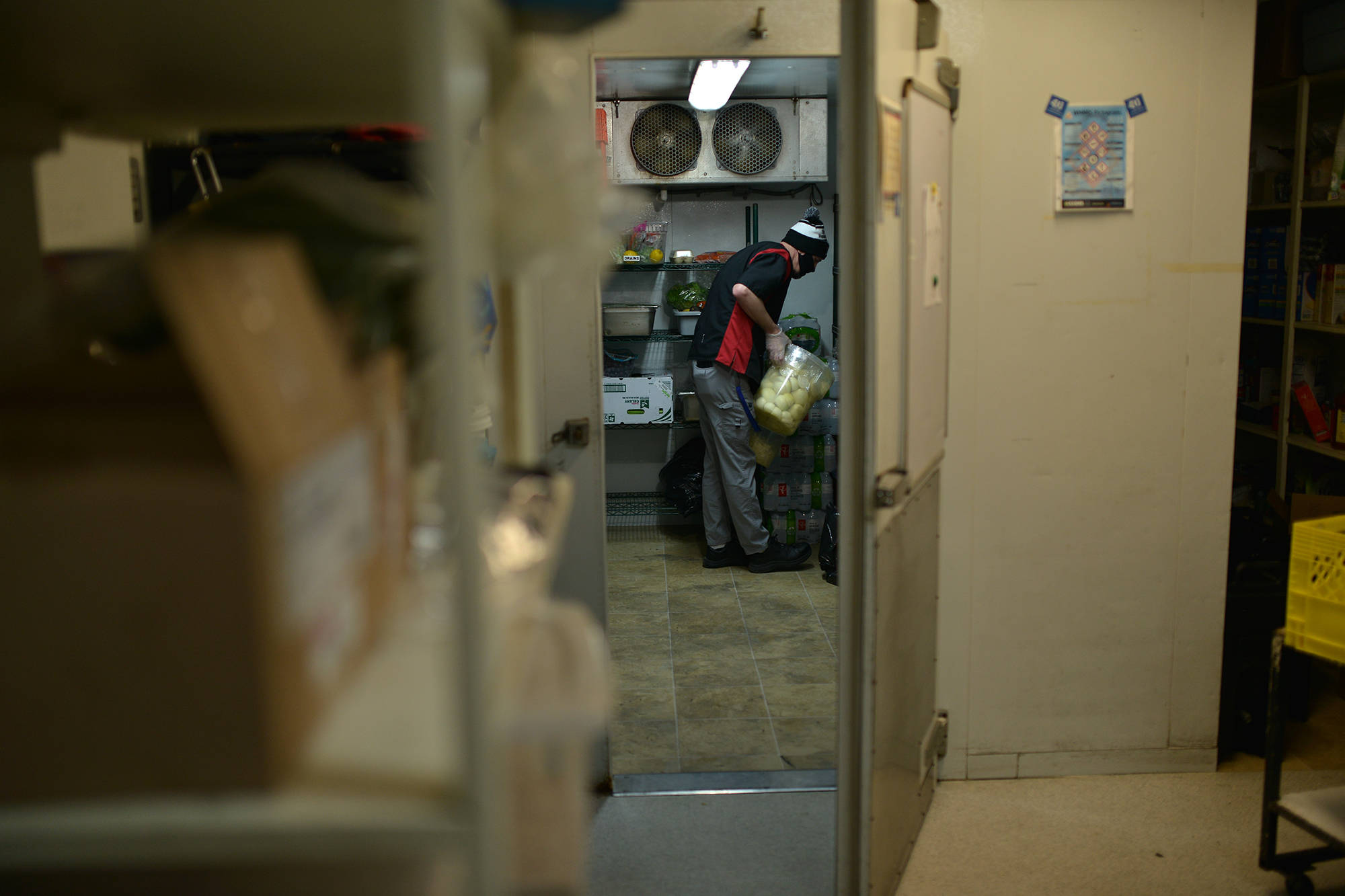 David Short fetches vegetables from the walk-in fridge at the Gospel Mission shelter kitchen, on Jan. 26. (Phil McLachlan - Capital News)