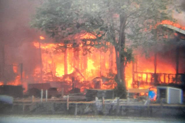 A fully involved cabin fire has spread to nearby homes off Westside Road Friday, June 4 near Komasket Beach. (Darlene Lynn photo)