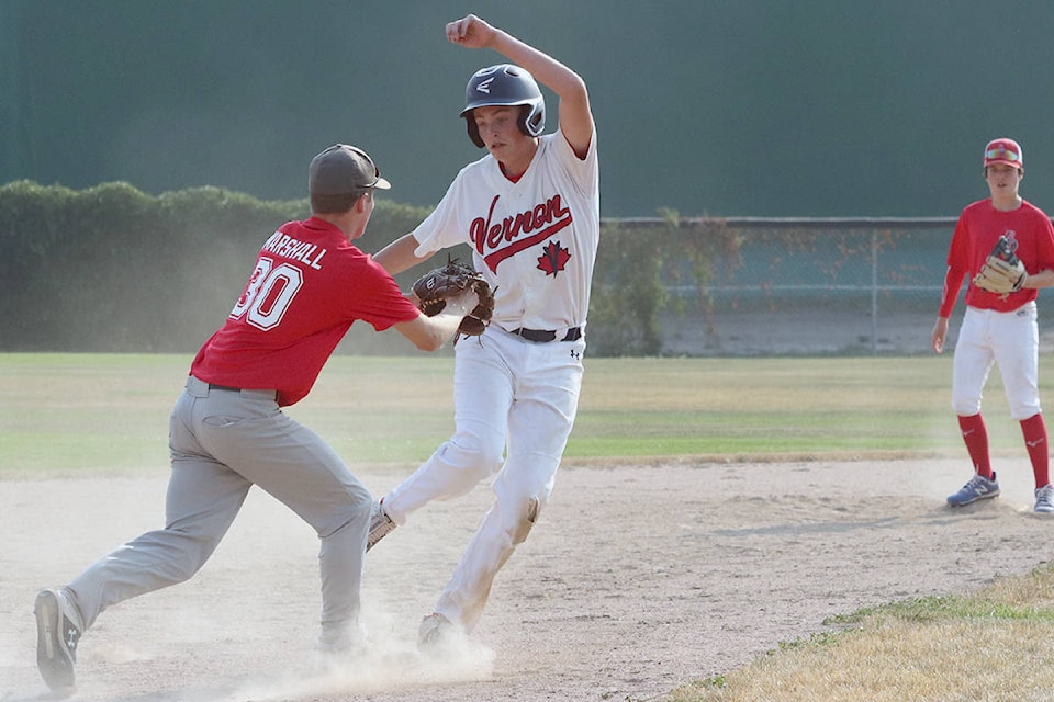 Vernon Canadians runner Reece Holmes tries unsuccessfully to avoid the tag from Kelowna Sun Devils shortstop Logan Marshall during Okanagan AA Midget Baseball exhibition play Sunday, July 11, at Vernon’s Marshall Fields. (Roger Knox - Black Press)