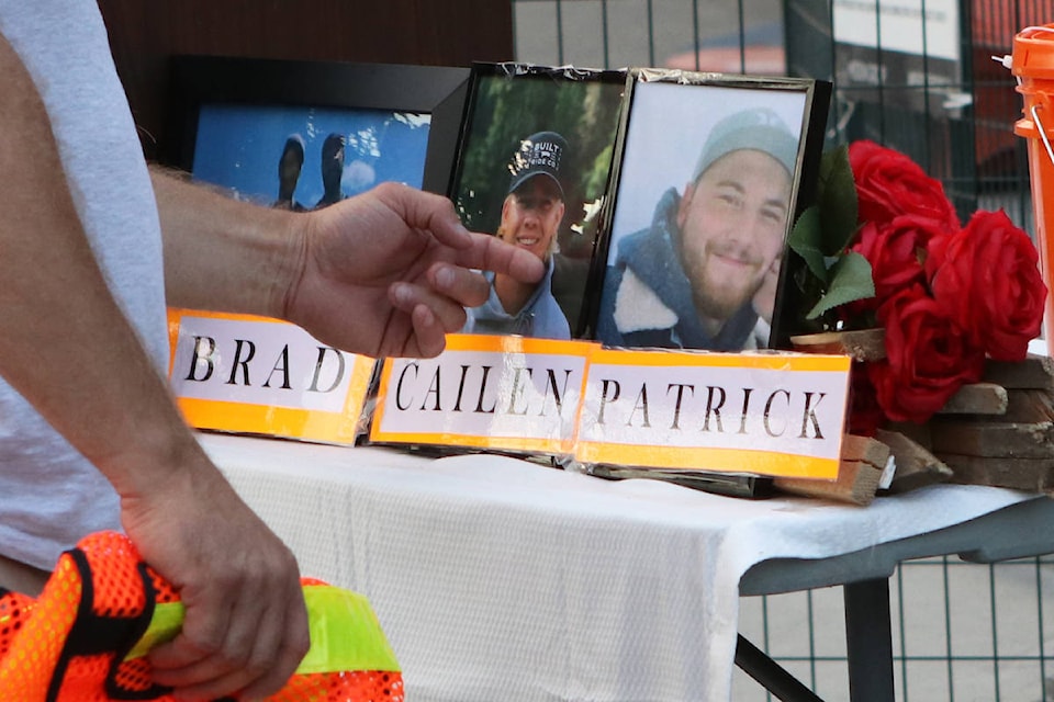 Chris Vilness, the father of 23-year-old Cailen Vilness, brushes a photo of his son at the vigil site. (Aaron Hemens/Capital News)