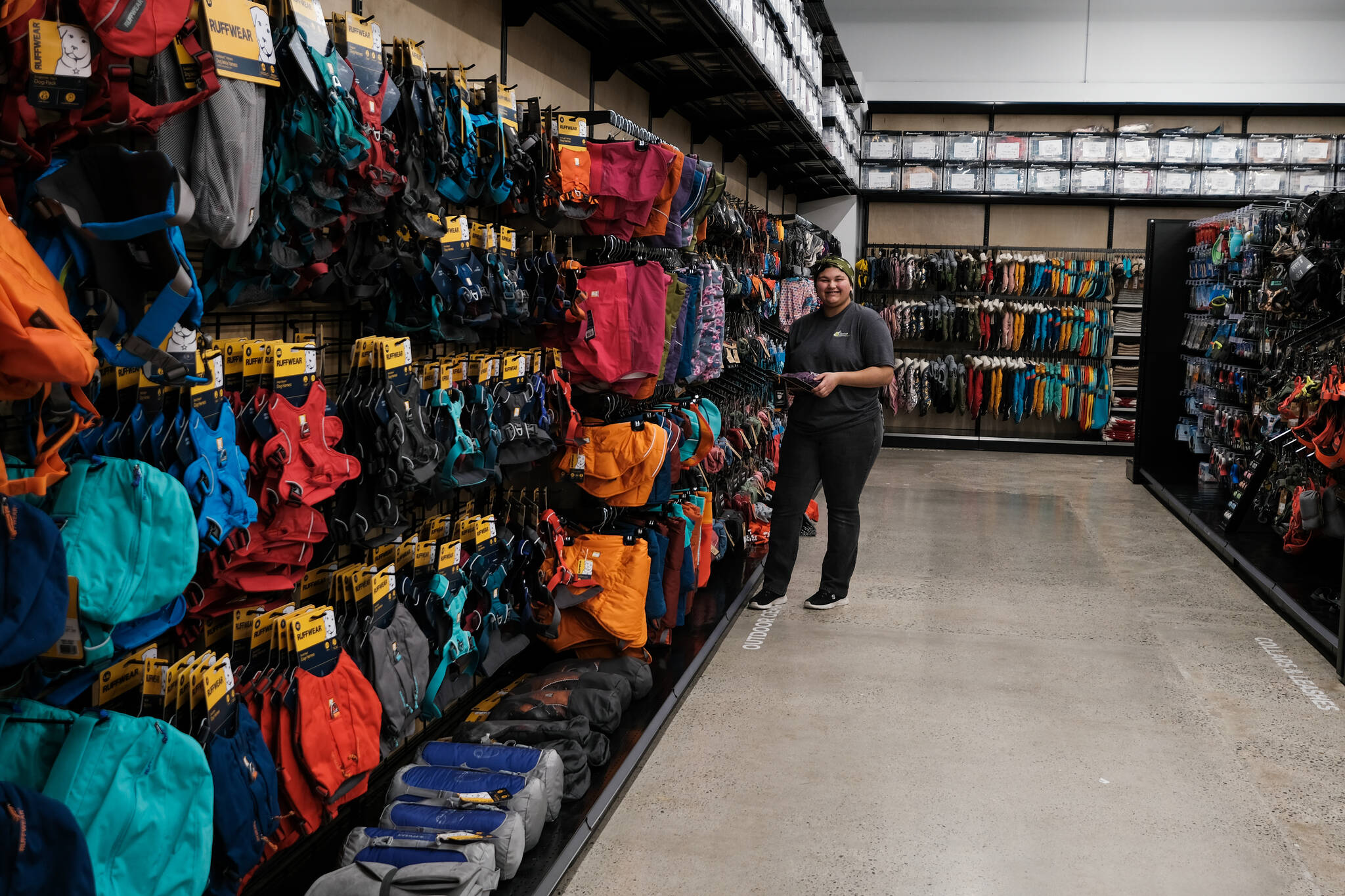 An employee keeping the shelves stocked with colourful gear for dogs (Jacqueline Gelineau/Capital News)