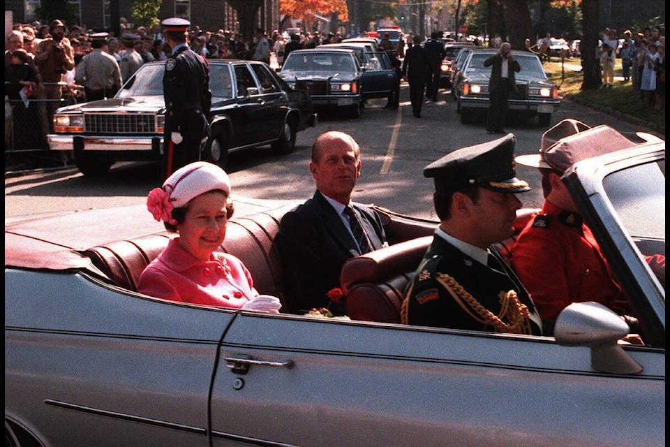 Queen Elizabeth II and Prince Philip, the Duke of Edinburgh, in an open car after attending ceremonies at Victoria Park in Moncton, N.B., Sept. 24, 1984. THE CANADIAN PRESS/Fred Chartrand