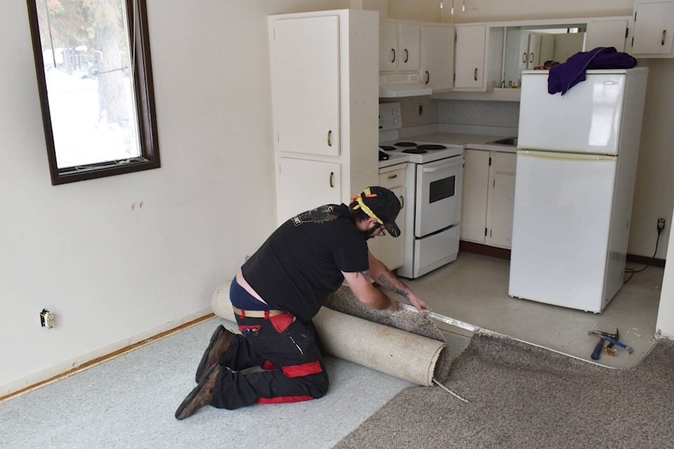 Jeff VanDooyeweert, Eagle Valley Road Rescue deputy chief, pulls up carpet in a unit at The Haven seniors㽶Ƶֱ living complex in Sicamous as the 48-year old unit undergoes a renovation. (Rebecca Willson- Eagle Valley News)