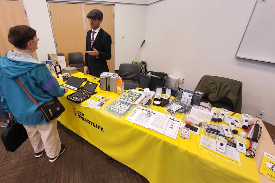 CNIB Foundation SmartLife store representative Luke Jukes (right) discusses technology for the visually impaired with Desert Cove’s Pauline Huth during the CNIB Mobile Stop in Vernon Thursday, May 25, at the Okanagan Regional Library. (Roger Knox - Morning Star)