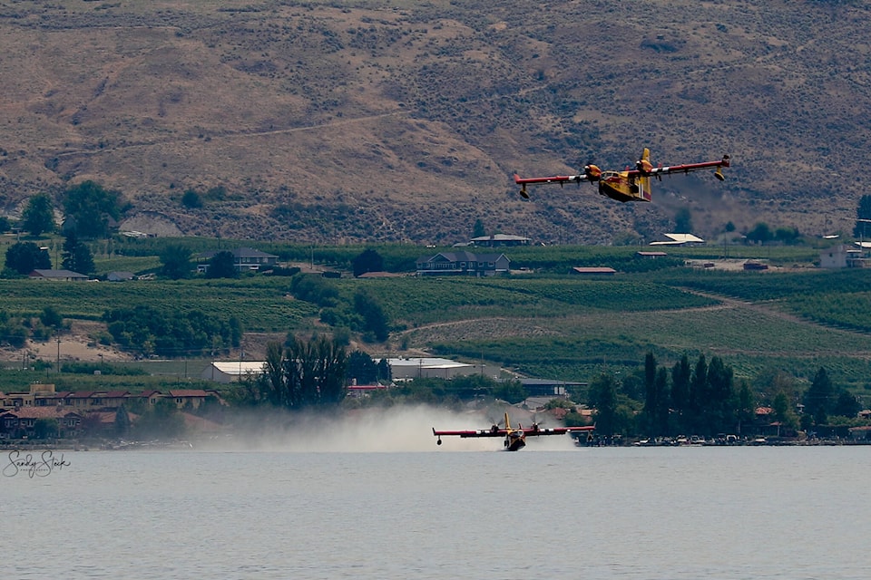 Air crews reload their water tanks on Osoyoos Lake while fighting the Eagle Bluff Wildfire on July 30. The air tankers worked tireless on the fire as did many contributing firefighters on Sunday. The wildfire remained out of control on July 31, though many evacuation orders had been lifted. (Sandy Steck - Contributed)