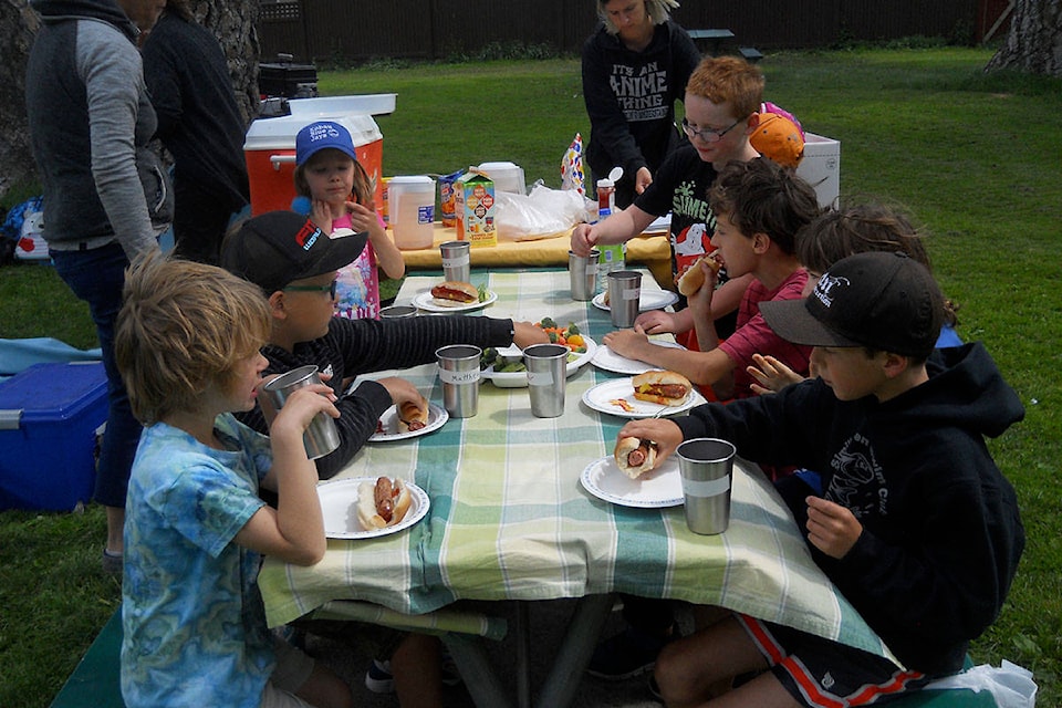 Tucking in at lunchtime barbecue during Day Camp at Memorial Park in Keremeos. (Contributed)