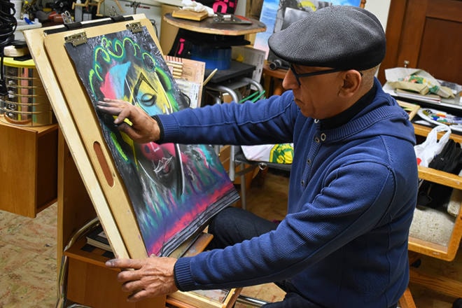 Siyamak Ghaffari, one of the artists in residence with the Penticton & District Community Arts Council’s Arts Matter program, works on his latest piece during the Hello Santa! Art Walk on Nov. 21. (Brennan Phillips - Western News)