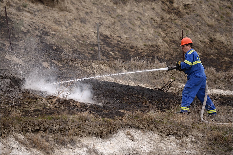 The grass fire on Old Airport Road came to a halt at about 3:15 p.m., thanks to suppression by crews on scene, as well as a rock face. (Phil McLachlan - Western News)