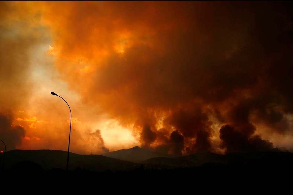 Smoke spreads over Parnitha mountain during a wildfire in Ippokratios Politia village, about 35 kilometres (21 miles), northern Athens, Greece, Friday, Aug. 6, 2021. Thousands of people fled wildfires burning out of control in Greece and Turkey on Friday, including a major blaze just north of the Greek capital of Athens that claimed one life, as a protracted heat wave left forests tinder-dry and flames threatened populated areas and electricity installations. (AP Photo/Lefteris Pitarakis)