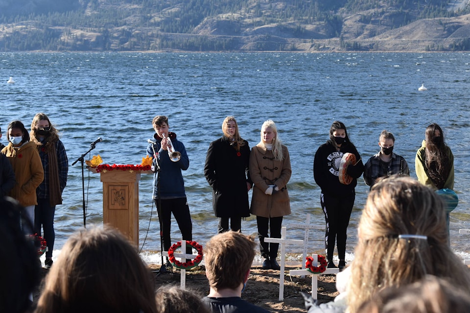 Princess Margaret Secondary student Marcus Francisco plays the Last Post to end the Remembrance Day ceremony on the shores of Skaha Lake Nov. 10, 2021. (Monique Tamminga Western News)