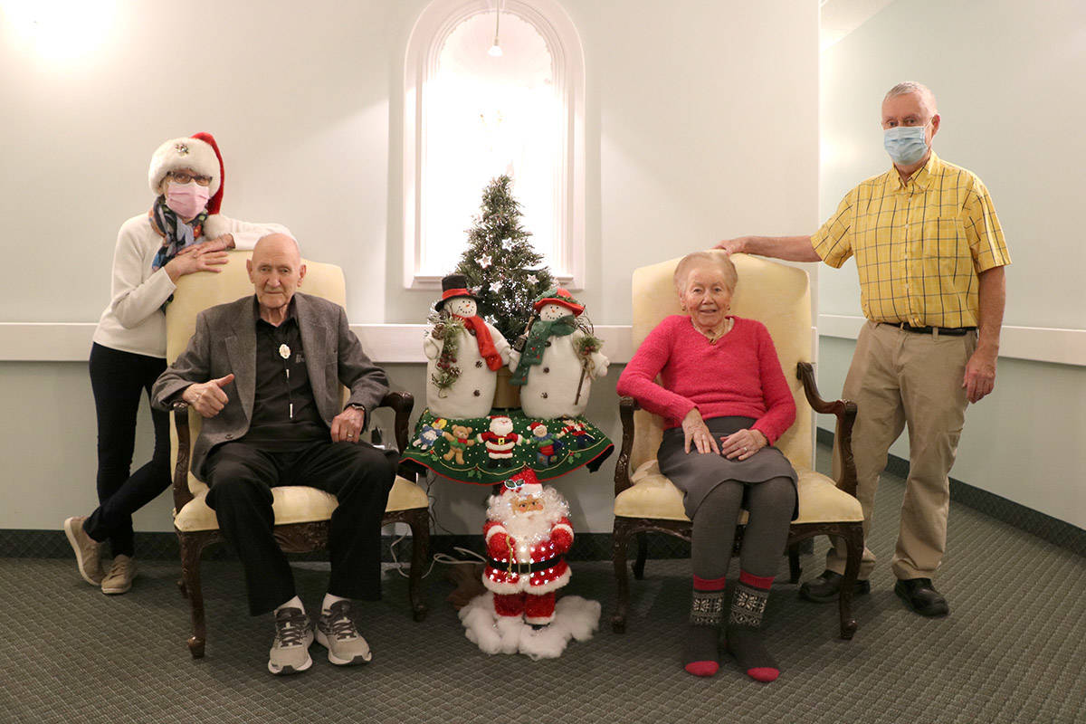 Residents John Carter and Maria Pasin enjoy the decorations that (masked) Irene and John Montgomery put up to brighten Chateau Manor over the holidays. Photo: Jim Bailey