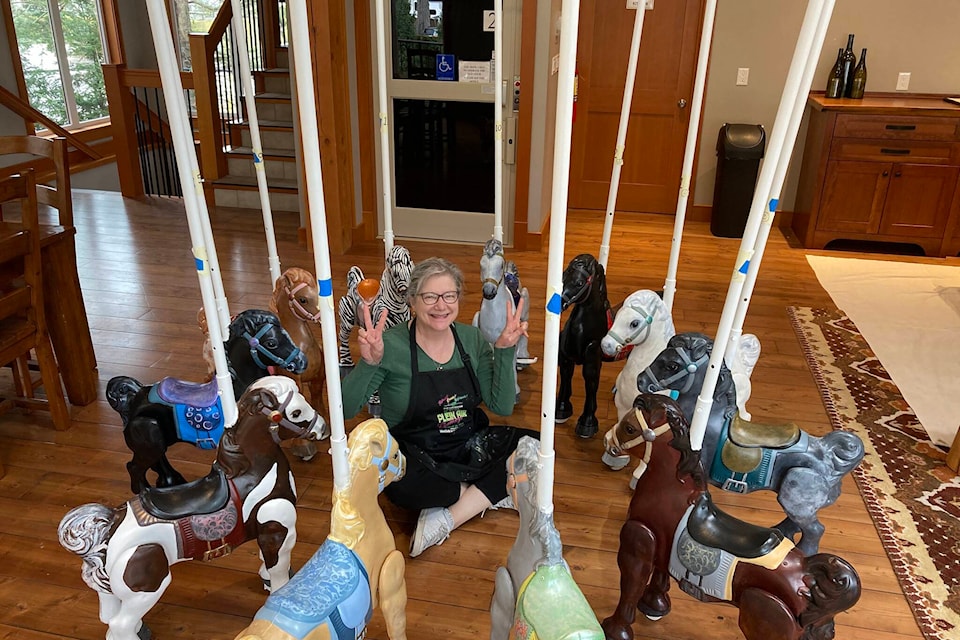 Artist Annette Resler poses, surrounded by recently restored carousel ponies. The carousel has made an appearance across the Lower Mainland, including in Vancouver, Chilliwack and here in Agassiz. (Photo/Annette Resler)