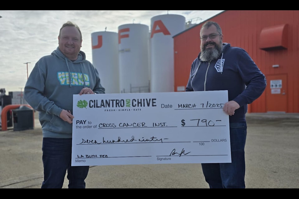 Cilantro and Chive's February Burger of the Month guest chef Lacombe Aaron Heck and Cilantro and Chive co-owner Rieley Kay pose with a cheque for the Cross Cancer Institute. 
(Photo submitted)