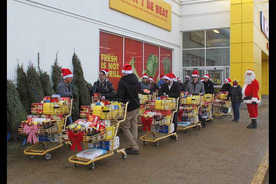 Gary Moe Chrysler Dodge Jeep Ram, Weidner Motors Ltd., and Empire Auto Sales came together to raise $5, 500 in food and donations for the Lacombe Food Bank. With a bit of help from Santa, staff walked the carts full of food donations down to the food bank from Lionel’s No Frills in Lacombe on Nov. 30. (Christi Albers-Manicke/LACOMBE EXPRESS)