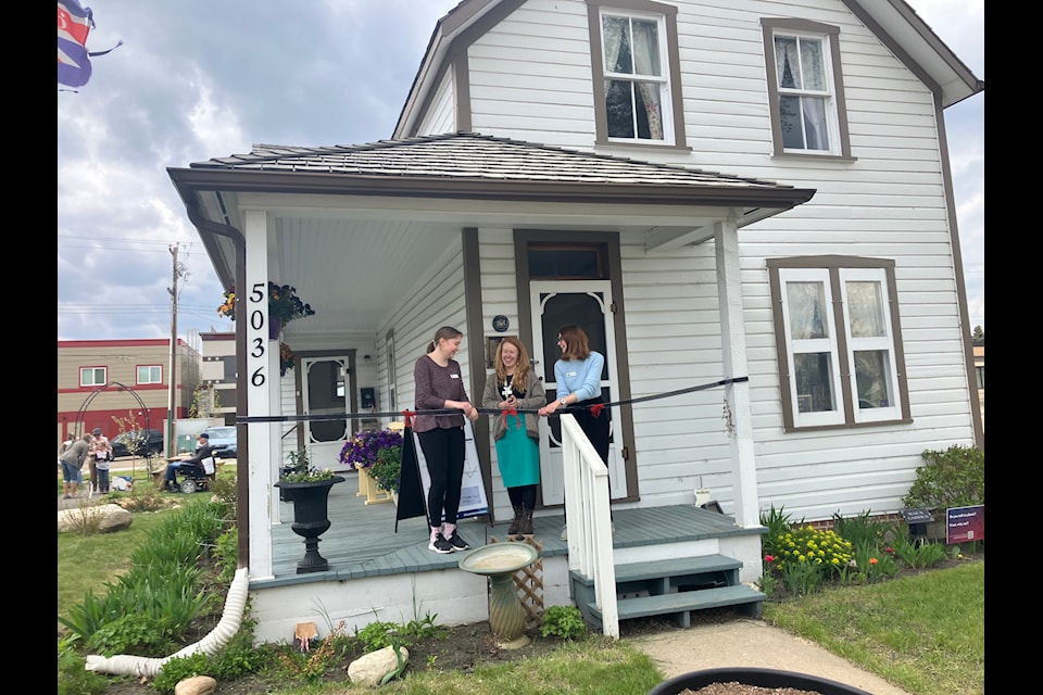 Staff cut the ribbon during the Michener House Museum grand re-opening on May 25.
