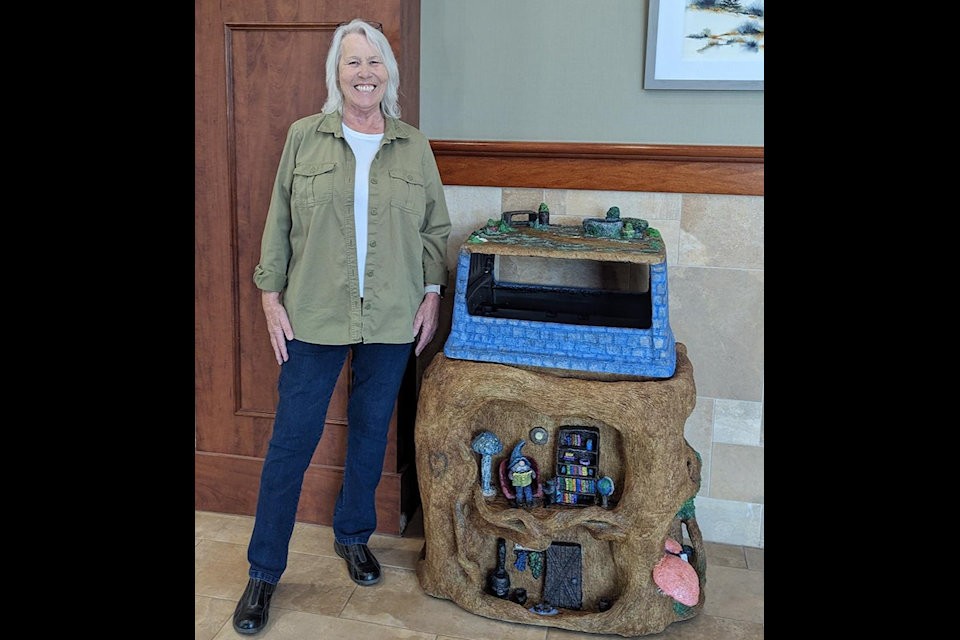 Lacombe artist Terry Walker poses beside a trash receptacles at the Lacombe Memorial Centre  that she has transformed into a 'gnome home'.
(Photo submitted)