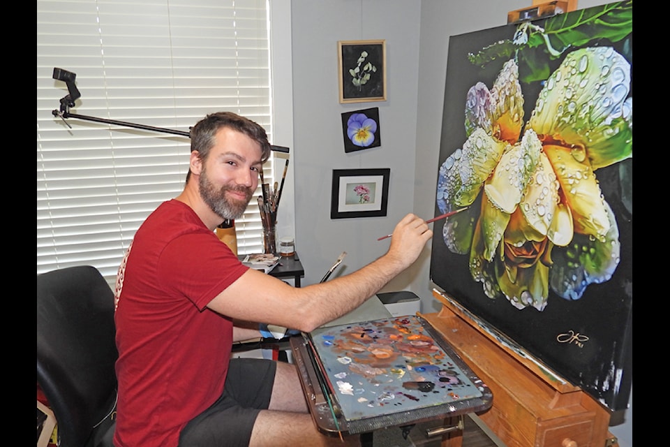 Local professional artist Tylor McNeil is putting finishing touches to a colourful painting of a beautiful flower covered in water droplets. McNeil has a showing of his works at Victoria’s famous Butchart Gardens this summer. (Duck Paterson photo)