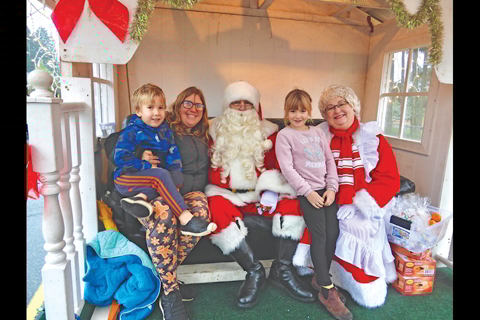 Santa and Mrs. Claus visit with members of the Taylor family, Travis, Mandy and Hailey. 