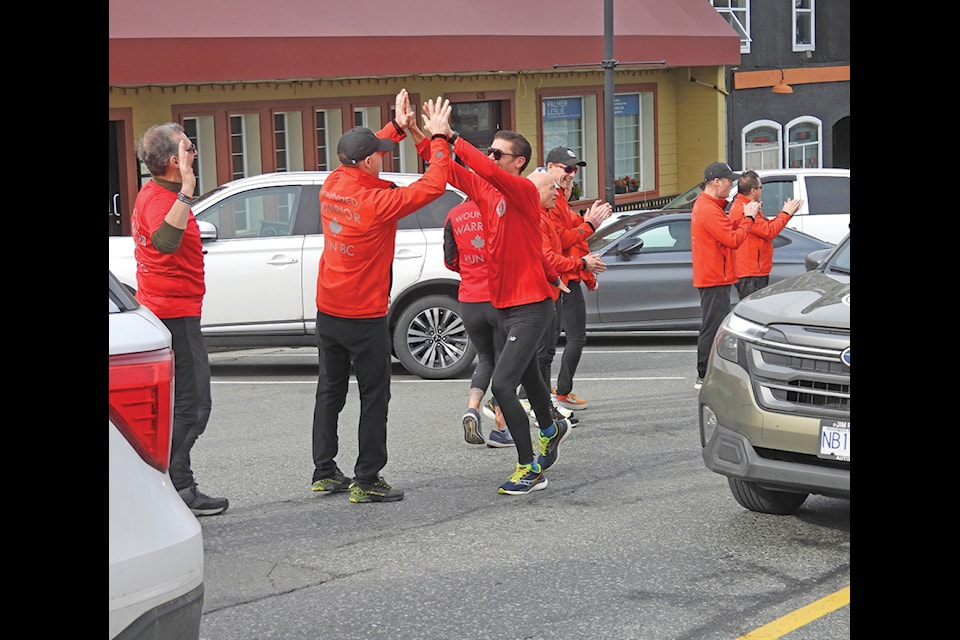 The support team and members of the Wounded Warriors run welcome runner Matt Carlson on his arrival into downtown Ladysmith last Saturday. Carlson, since 2018 has been the head runner, support runner and finish line coordinator. (Duck Paterson photo)