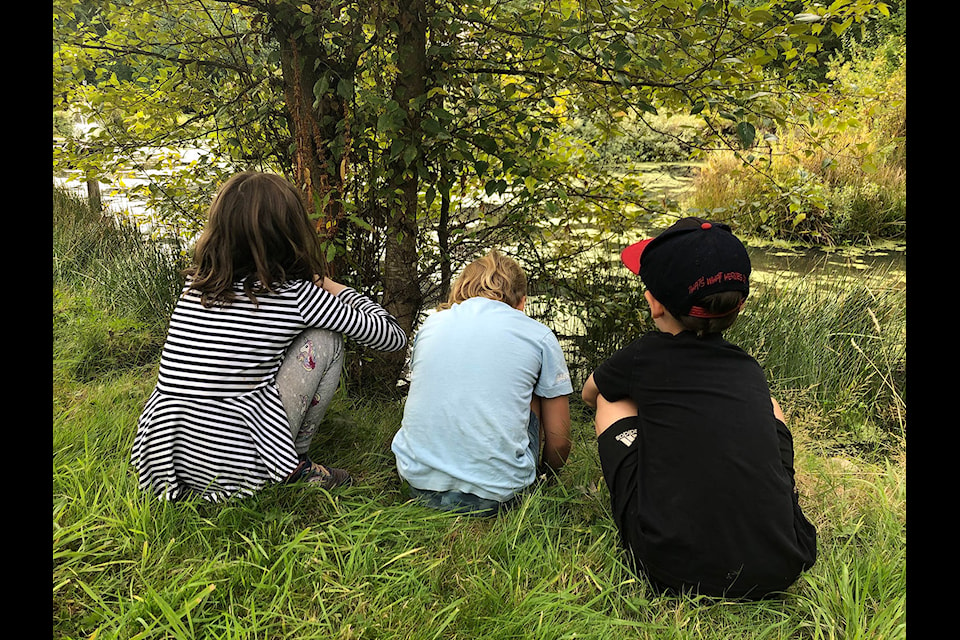 Youth in the Outdoor Explorers program investigate the edge of Patti Gisbourne’s duck pond. (Sense of Place photo)