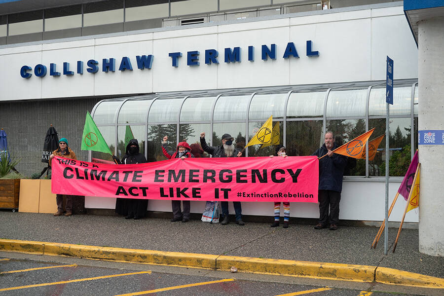 A small group of Extinction Rebellion members and supporters gather at the Nanaimo Airport to protest emissions caused by air travel on Oct. 25. One man was arrested after walking onto the tarmac. (Photo by Tyler Hay)