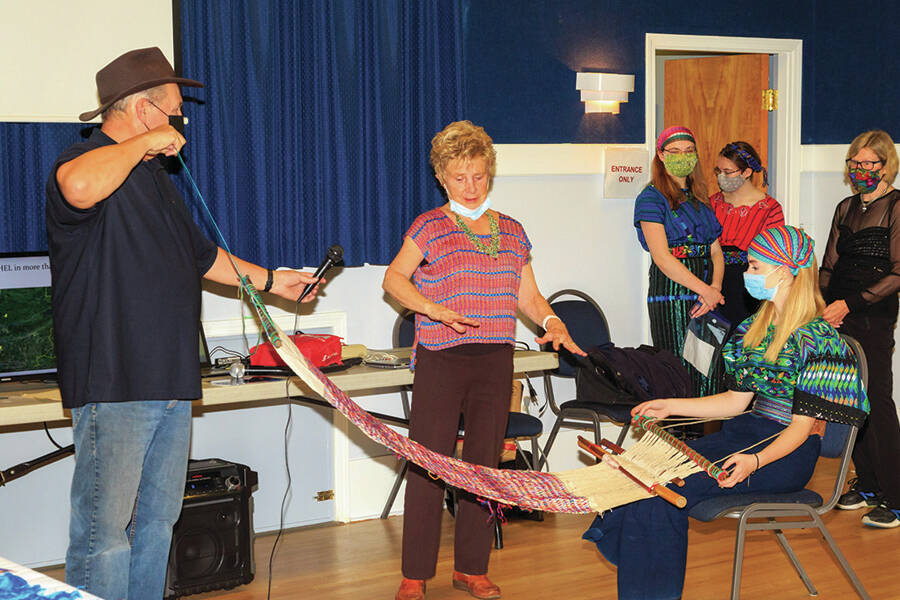 Jacqueline Sheppard demonstrates how a backstrap loom works with help from Gerry Beltgens and Faith Ross. (Photo by Art Carlyle)