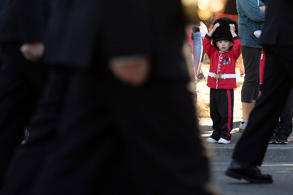 A little boy dresses up to watch on Quadra Street as the ceremonial procession and provincial commemorative service for Queen Elizabeth II passes along. (Arnold Lim/Black Press Media)