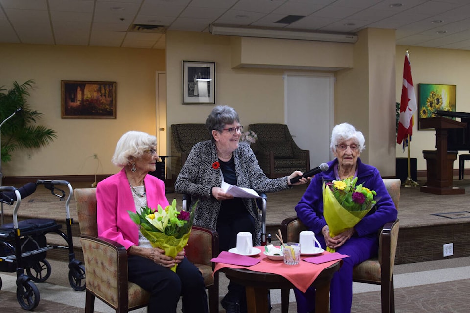 Eula Johnson, 105, and Eleanor Pattison, 102, share details about their lives with friends at The Wellesley. (Hollie Ferguson/News Staff)