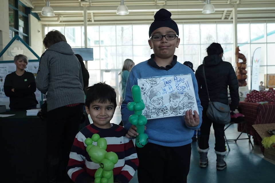 Kunwar and Rajvir hold up balloon animals and a drawing. - Dustin Betuzzi