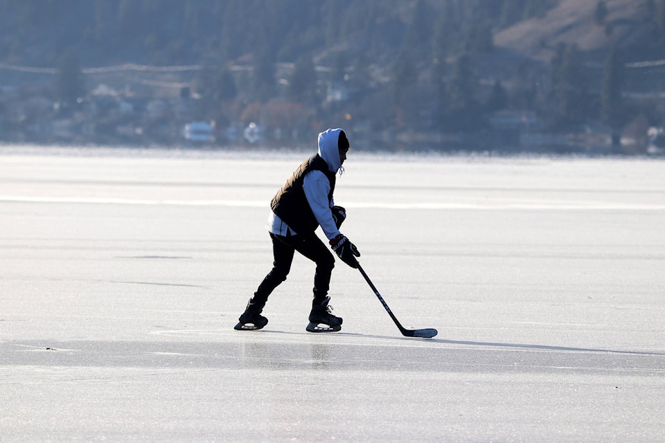 Youngbin Kim skates the puck down Okanagan Lake while playing hockey with some friends Friday afternoon off Kin Beach. (Jennifer Smith - Morning Star)