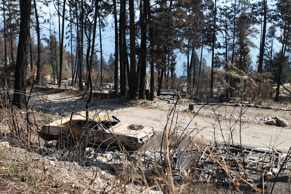 A damaged car sits near a Killiney Beach property on Aug. 24, one of the Westside Road areas impacted by the White Rock Lake wildfire. (Aaron Hemens - West K News)