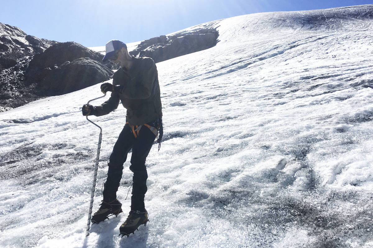 Ben Pelto drills into Kokanee Glacier in August 2022. Behind him are rock formations that were under ice when he began visiting the glacier in 2014. Photo: Heather Shaw