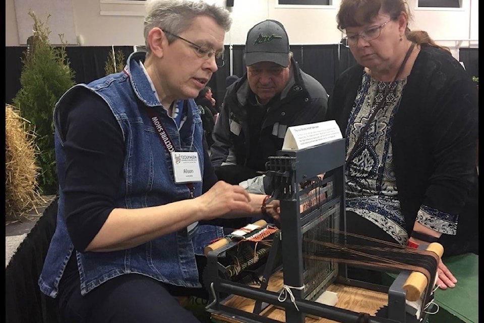 The Tzouhalenm Spinners and Weaters Group’s Alison Irwin shows onlookers how to use a loom during the Islands Agriculture Show Friday at the Cowichan Exhibition grounds. (Sarah Simpson/Citizen)