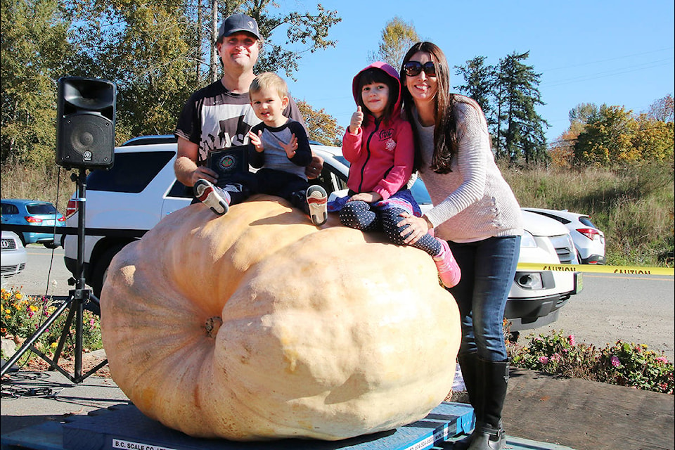 The Carley family: Scott, left, two-year-old Cyrus, four-year-old Milana, and Kirstin, enjoy their victory at the Old Farm Market Oct. 13 for heaviest pumpkin. For more, see page 17. (Lexi Bainas/Citizen)