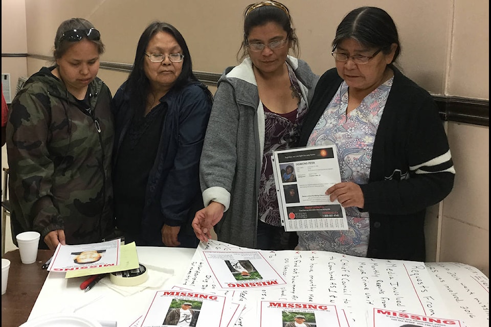 Josephine Joe, Helen Joe, Elizabeth Louie, and Donna Louie survey posters of their missing relatives as they prepare for the annual Walk for Missing and Murdered Men, Women and Children. (Warren Goulding/Citizen)