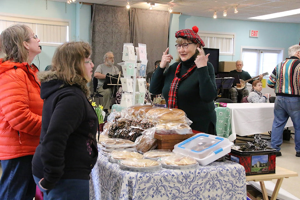 Katherine Swan chats about the Scottish tam and scarf she’s wearing while working at the home baking table at the 50 Plus Centre’s first Spring Market. (Lexi Bainas/Citizen)