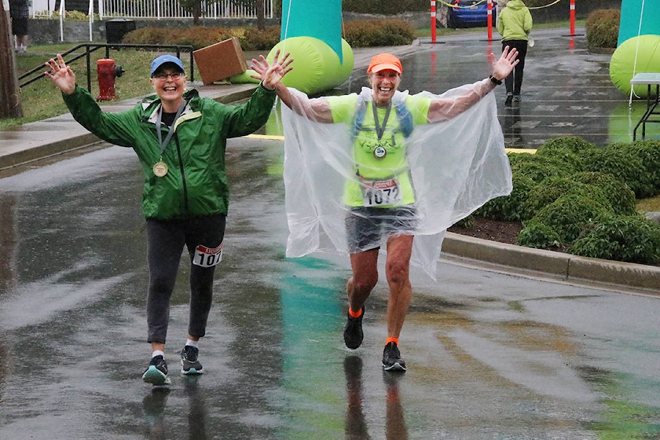 Janice Youds and Jane Swintak finish the Lake to Lake Walk and Marathon in a pouring rain Saturday afternoon, Sept. 14. (Lexi Bainas/Gazette)
