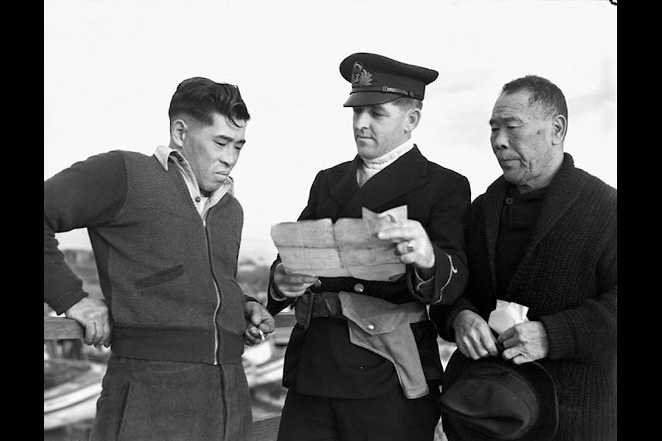 Japanese Canadian fishermen having their boat confiscated by a Royal Canadian Navy Officer, 1941. (Library and Archives Canada photo)
