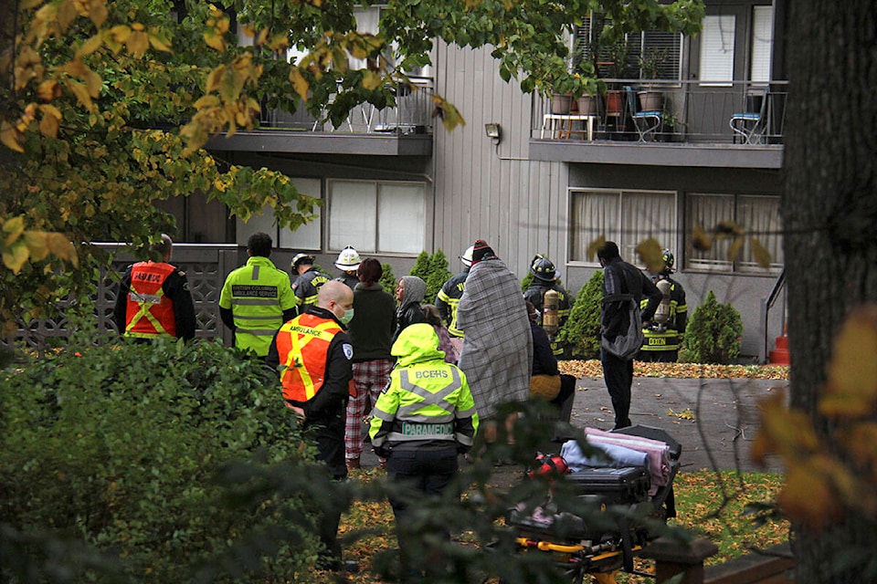 Emergency crews and residents stand outside while firefighters tackle what remains of the fire. (Jane Skrypnek/News Staff)