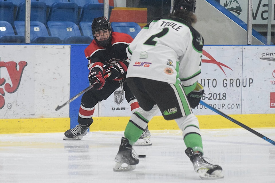 Port Alberni Bombers forward Gavin Mastrodonato dishes a pass past Lake Cowichan Kraken defender Ethan Toole during a game at the Alberni Valley Multiplex on Feb. 15, 2022. (ELENA RARDON / ALBERNI VALLEY NEWS)