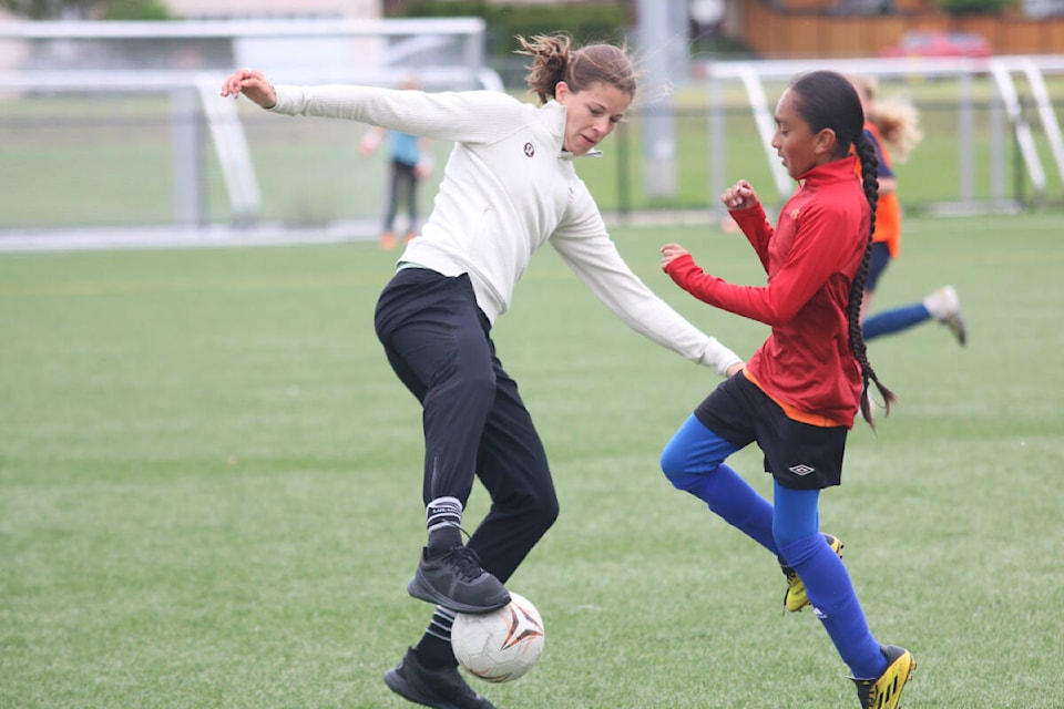 Stephanie Labbé keeps the ball away from Moses Sylvester during a scrimmage with young players at the Sherman Road soccer turf last month. (Kevin Rothbauer/Citizen)