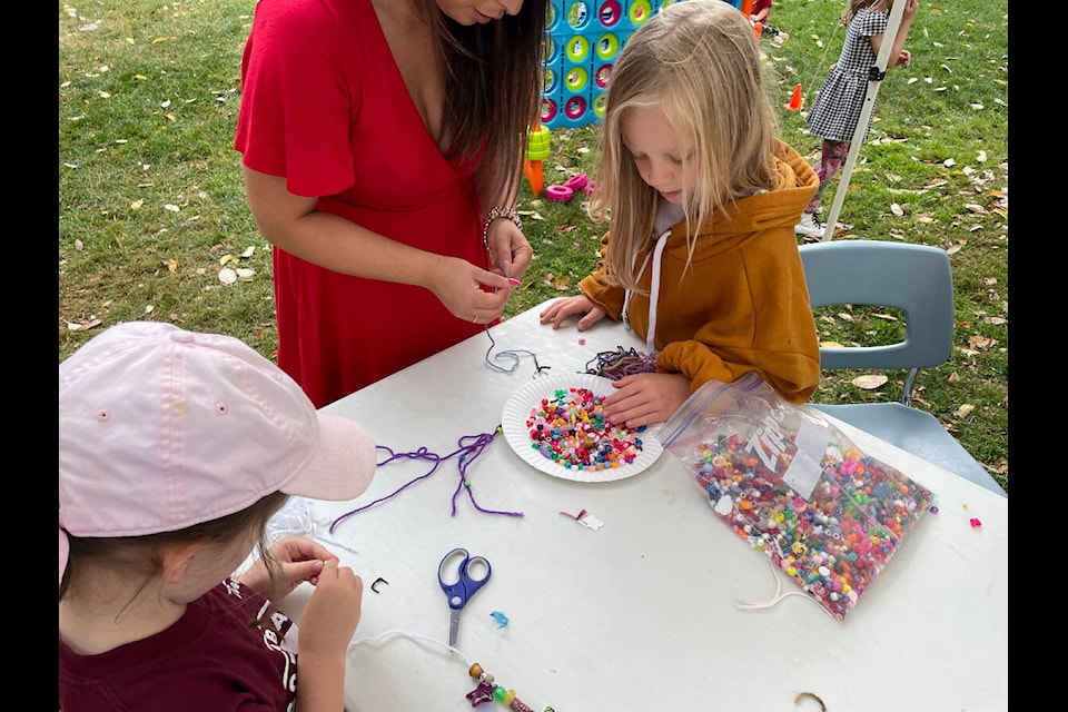 Girls string beads in an art project. (Sarah Simpson/Gazette)